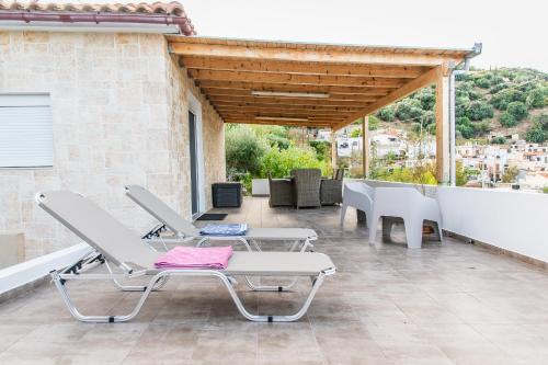 eine Terrasse mit einem Tisch und Stühlen auf einem Gebäude in der Unterkunft Chic & Spacious House in Rodia Heraklion in Iraklio