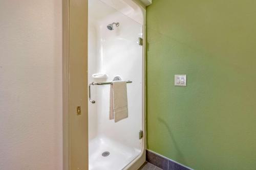 a shower in a bathroom with a green wall at Sleep Inn Henderson in Henderson