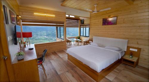 Schlafzimmer mit einem weißen Bett und Holzwänden in der Unterkunft Vrindhavan Farm Suites in Kanthalloor