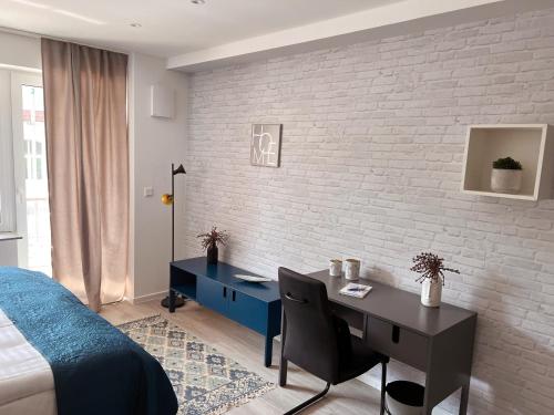 a bedroom with a desk and a brick wall at SOFI-LIVING-APARTMENTS in Hannover