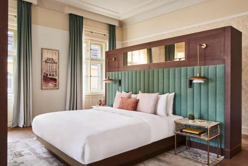 a bedroom with a large white bed with a green wall at Andaz Prague - a Concept by Hyatt in Prague