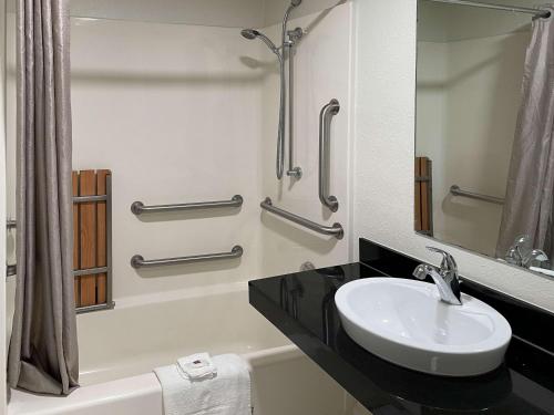 uma casa de banho com um lavatório, um chuveiro e um espelho. em Motel 6 Hagerstown MD em Hagerstown