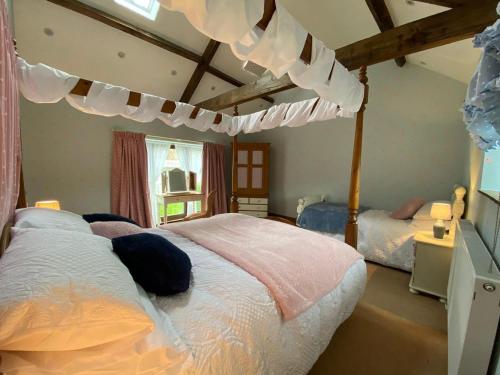 a bedroom with a bed with a canopy at Lily Rose Cottage in Gilsland