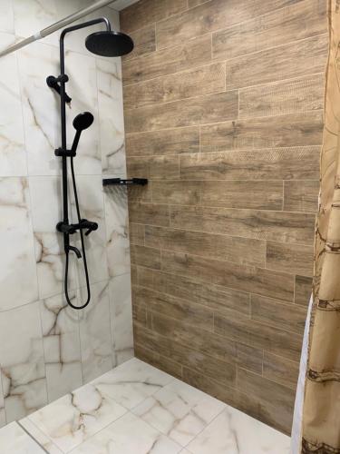 a bathroom with a shower with a stone wall at City Central Apartment in Yerevan
