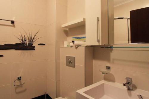 ein weißes Badezimmer mit einem Waschbecken und einem Spiegel in der Unterkunft Studio apartment in the centre of Budva in Budva