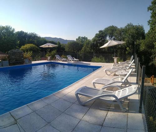una piscina con tumbonas y una piscina en Cerro Negro, Complejo en Villa General Belgrano