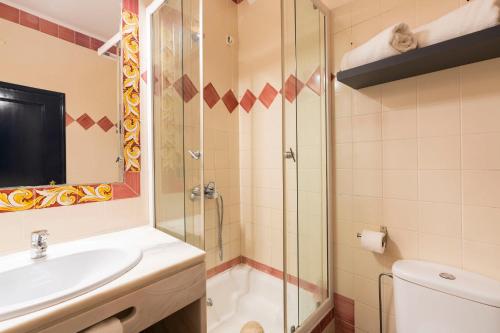 a bathroom with a shower and a sink and a toilet at D'Iberica Alojamento in Évora