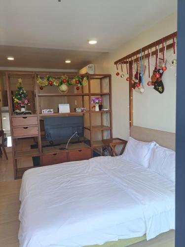 a bedroom with a white bed and a tv at Timurbay Beach Resort Balok Kuantan in Kampung Sungai Karang