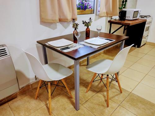 - une table avec 2 verres à vin et 2 chaises dans l'établissement Centro RG, à Río Gallegos