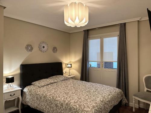 sypialnia z łóżkiem i żyrandolem w obiekcie Apartamento Axpelarru w mieście Ochandiano