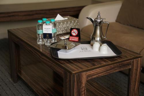 a coffee table with a tray with a tea kettle on it at La Rive Hotels & Suites in Dammam