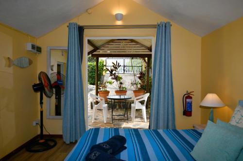 Schlafzimmer mit einem Bett, einem Tisch und Stühlen in der Unterkunft Fenetre sur Mer in Rodrigues Island