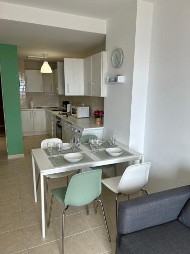 a kitchen with a table with four chairs and a tableasteryasteryasteryasteryastery at Il Paradiso Esiste in Costa Calma