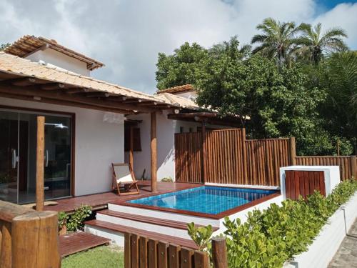 une arrière-cour avec une piscine et une maison dans l'établissement Casa, 2 Suítes com Ar, Piscina a 400 mts Praia - Taipu de Fora, Barra Grande #4, à Marau