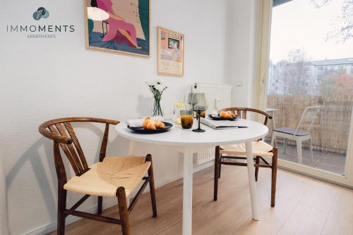 mesa de comedor con 2 sillas y mesa blanca en Stilvolles Apartment im Zentrum mit Netflix WE42 en Magdeburgo