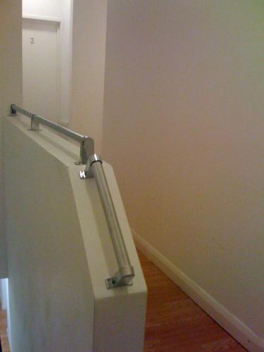 a white wall with a metal hand rail in a room at Nite Inn Bed & Breakfast in Leeds
