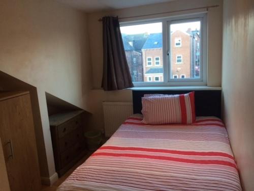 a small bedroom with a bed with a window at Nite Inn Bed & Breakfast in Leeds