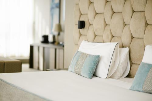 a bedroom with a bed with pillows on it at Hotel AMI Budva Petrovac in Petrovac na Moru