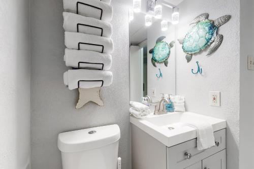 a bathroom with a sink and a toilet and towels at Victorian Condo #9312 in Galveston