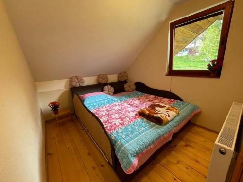 a small bedroom with a bed and a window at Family owned self sufficient ECO farm TARA in Pljevlja