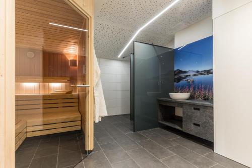 La salle de bains est pourvue d'une douche et d'un lavabo. dans l'établissement Familienhotel Botenwirt, à Kleinarl