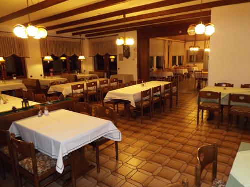 a dining room with tables and chairs with white tables at Hotel garni Zum Reinhardswald in Gewissenruh