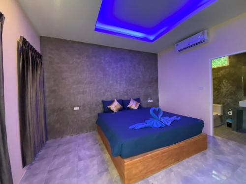 a bedroom with a bed with a blue ceiling at Kohyao Non Bay in Ban Nai Wat