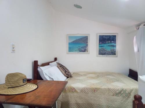 a bedroom with a bed and a table with a hat on it at Suite Ilha Grande in Angra dos Reis
