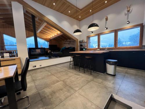 a kitchen with a bar and a living room with windows at Chalet Azalée, Montriond, Morzine, Avoriaz in Montriond