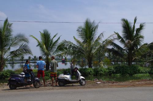 a group of people standing next to a scooter at Jojies Homestay Fortkochi in Cochin