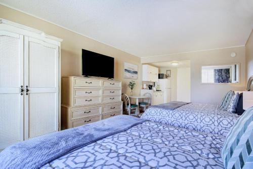 1 dormitorio con 2 camas, TV y tocador en The Condo on Ocean Blvd en Myrtle Beach