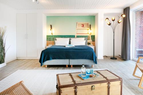 a bedroom with a bed and a coffee table at Hotel Bethanien in Langeoog