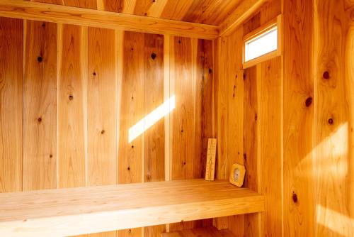 a wooden room with a sauna with a window at IZA近江舞子 in Minami-komatsu