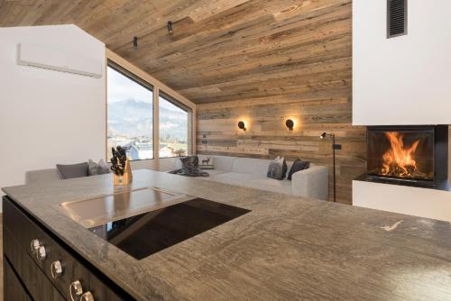 a kitchen and living room with a fireplace at Haus Sonnblick Chalet in Reith im Alpbachtal