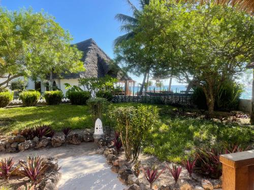 a garden in front of a house with trees at Aya Beach Resort in Kizimkazi