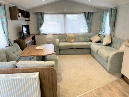 a living room with a couch and a table at Rockley Park Private Holiday Homes in Poole