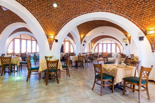 a dining room with tables and chairs and brick walls at Beach safari nubian resort in Marsa Alam City
