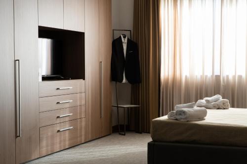 um quarto com uma cama e uma cómoda com uma televisão em Building Hotel em Teverola
