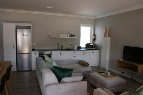 a living room with a couch and a kitchen at Botany House, in the heart of Hermanus in Hermanus