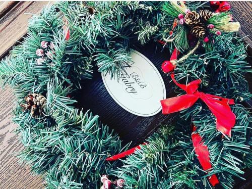 a christmas wreath with a red bow on a table at B&B Da Gabry in Fondi
