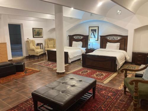 a bedroom with two beds and a couch and chairs at Al Fardous Luxury Vacation Home in King Mariout