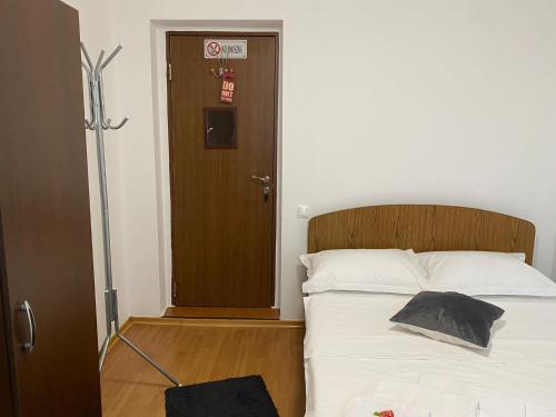 a bedroom with a bed with a wooden headboard and a door at La Olteanu in Brăila