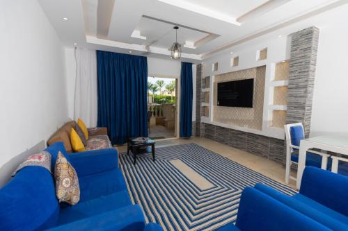 a living room with a blue couch and a fireplace at Palma Resort Hurghda in Hurghada