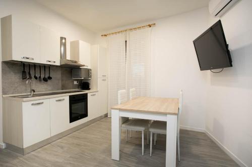 a kitchen with a table and a tv on a wall at Apartament al cor de Begur in Begur
