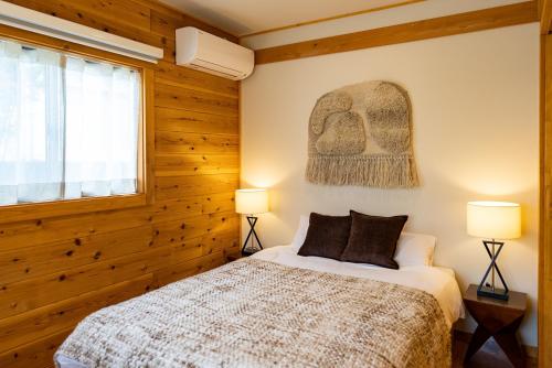 a bedroom with a bed and two lamps and a window at IZA近江舞子 in Minami-komatsu