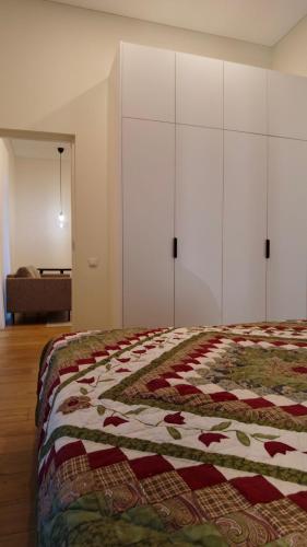a bedroom with a bed with a quilt on it at Žalio kalno apartamentai in Kaunas