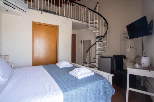 a bedroom with a bed and a spiral staircase at Bed and Breakfast Terra del Sole Ibla in Ragusa