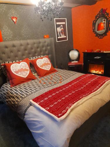 a bedroom with a bed with red pillows on it at LOVE ROOM Le rouge et noir in Barr