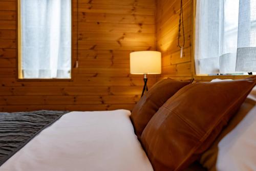 a bedroom with a bed with a lamp and windows at IZA近江舞子 in Minami-komatsu