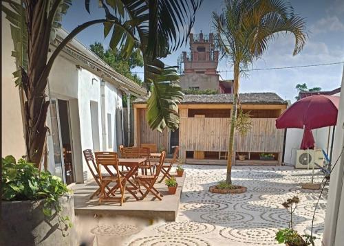 a patio with a table and chairs and an umbrella at Iarimbato Hotel in Antananarivo